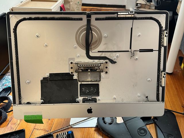 An iMac chassis with most of the component removed. Only a few stray wires remain.