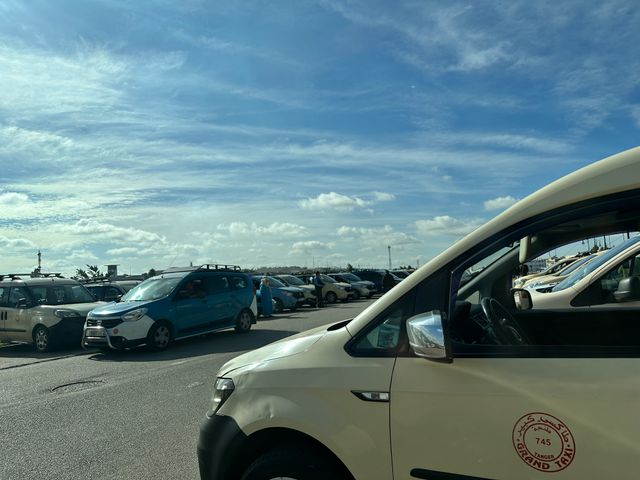 A parking lot full of beige minivans.