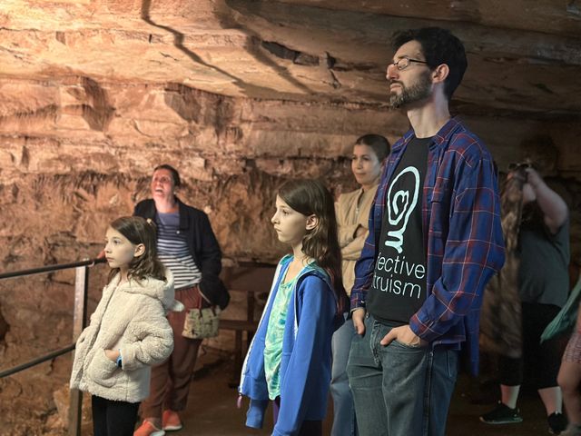 A crowd of people in a cavern with a railing on the left side.