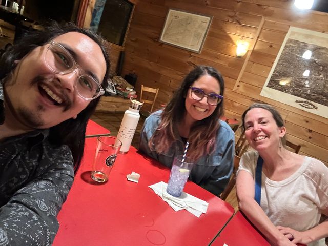 Selfie of myself (long-haired mid-30s east asian man) and two friends at a table in a bar