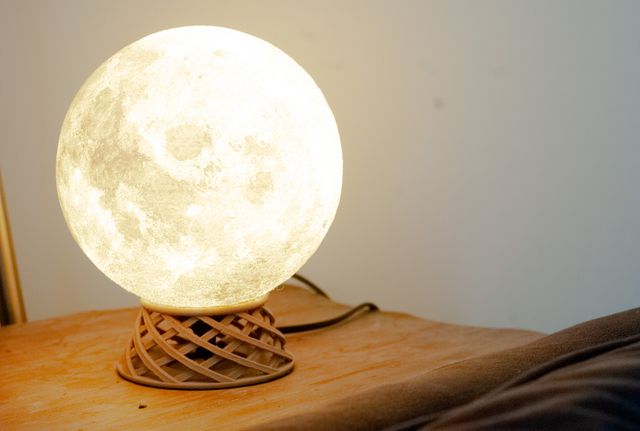 A glowing orb lamp sitting on a woven-looking round pedestal. It looks kind of like a crystal ball.